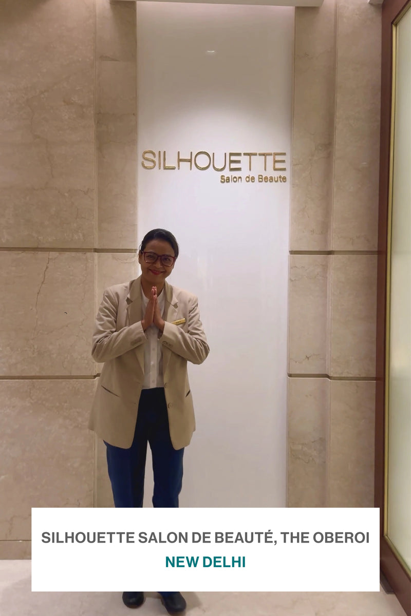 A staff member welcoming visitors at Silhouette Salon de Beauté in The Oberoi hotel, New Delhi, with Algotherm treatments on display.